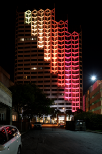 Yellow, orange, red lights on a high rise building cascading down. 